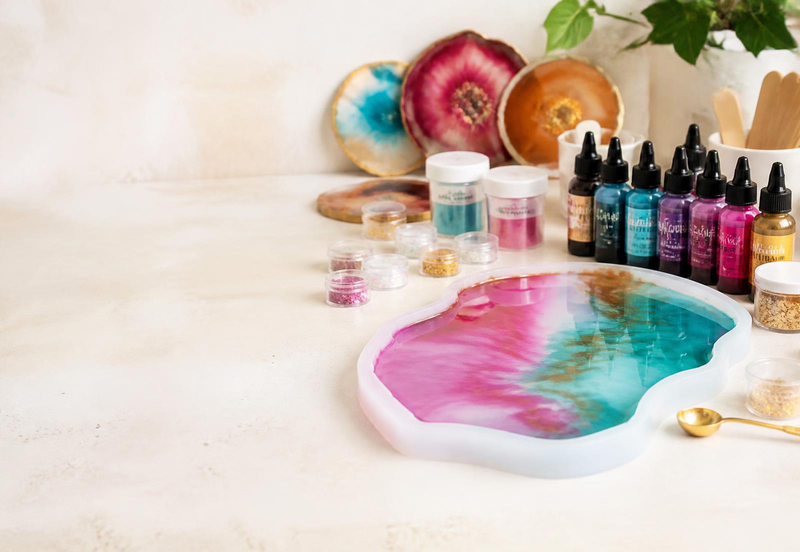 Resin art workbench with a freshly poured tray, pigments and alcohol inks